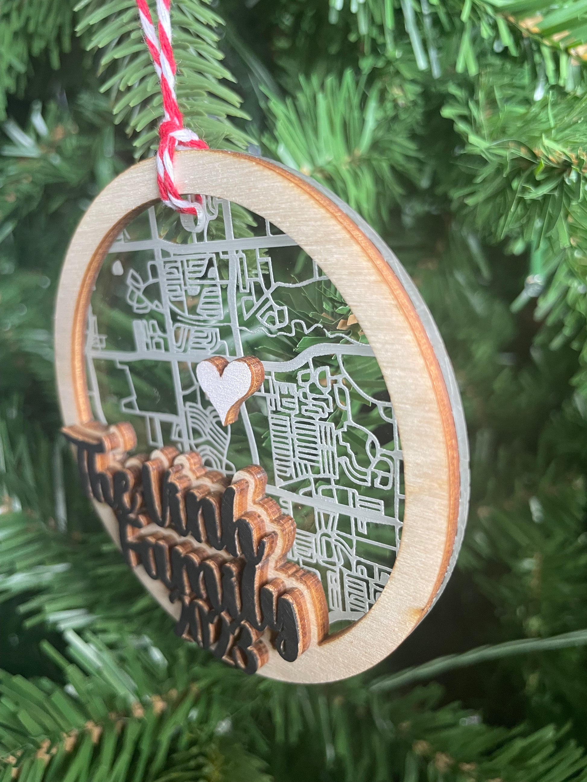 side view of acrylic and wood map ornament on green Christmas tree